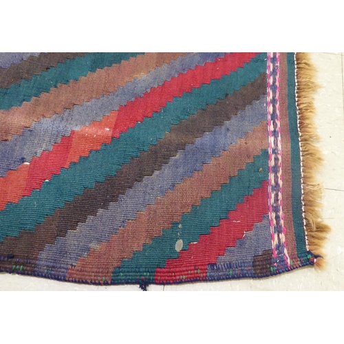 176 - A Kelim design rug, decorated with geometric patterns, on a multi-coloured ground  100