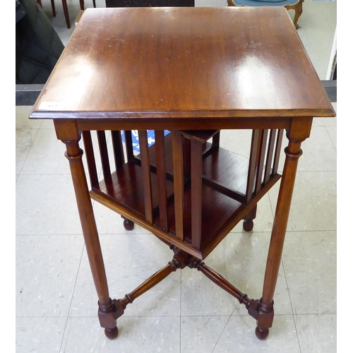 177 - An early/mid 20thC mahogany book table, the top over a rotating open, four division bookcase, raised... 