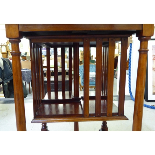 177 - An early/mid 20thC mahogany book table, the top over a rotating open, four division bookcase, raised... 