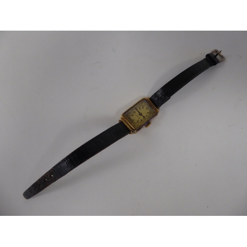 237 - A lady's Rolex 9ct gold cased wristwatch, faced by an engraved Arabic dial, on a black hide strap