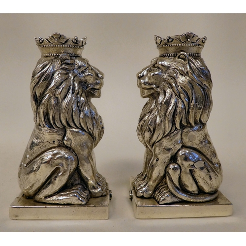 26 - A pair of silver coloured metal seated Heraldic lion condiments pots  stamped 800