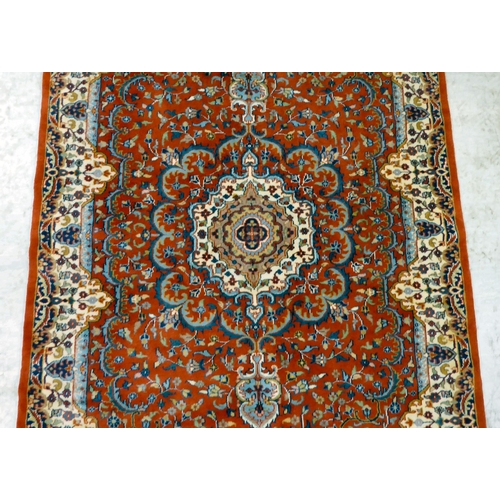 300 - A Persian rug, decorated with repeating floral designs, on a mainly red ground  50