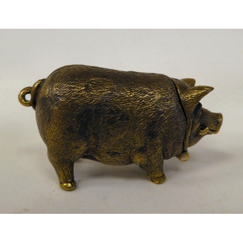 32 - A brass novelty vesta case, fashioned as a pig with a hinged cap