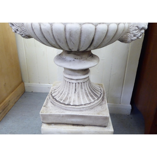 332 - A cream painted composition stone pedestal, twin handled urn, on a separate plinth  43