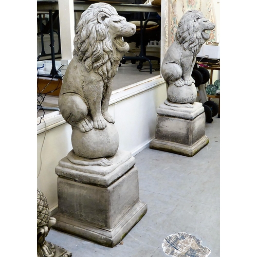 333 - A pair of modern composition stone lion terrace ornaments, sitting upon balls, on a separate plinth ... 