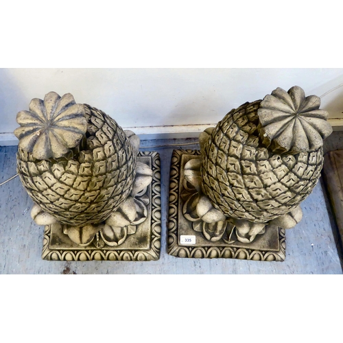 335 - A pair of modern composition stone finials, fashioned as pineapples, on a square plinth  19