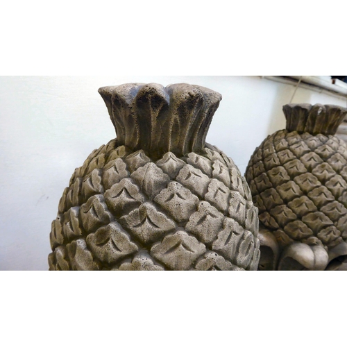 335 - A pair of modern composition stone finials, fashioned as pineapples, on a square plinth  19