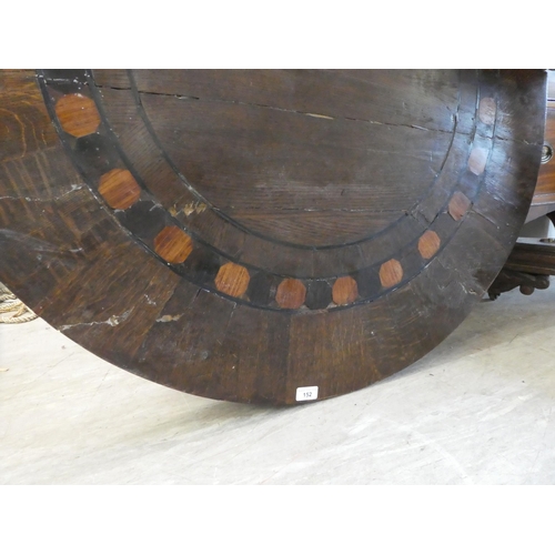 152 - A Victorian oak breakfast table with a decoratively inlaid centre, raised on a triform pillar, an in... 