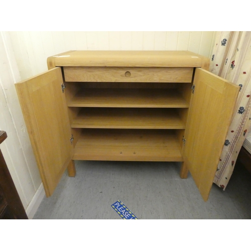 162 - A Habitat light oak sideboard, the pair of panelled doors enclosing a fitted interior, raised on sho... 