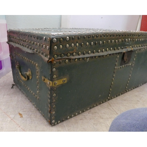 232 - An early 20thC green leather bound, studded trunk, bearing a coat of arms with straight sides and a ... 