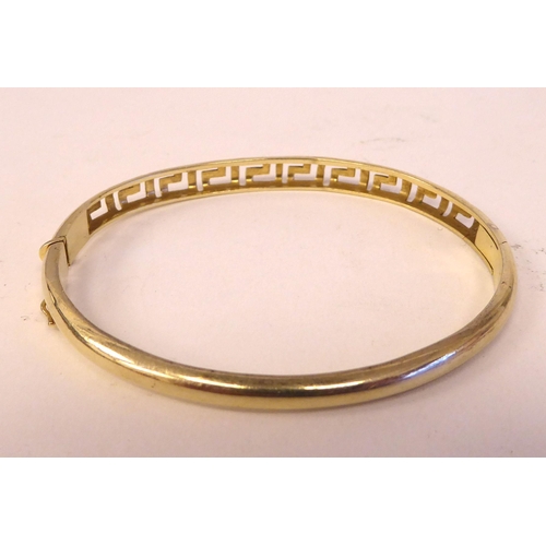 27 - A yellow metal hinged bangle  stamped 585