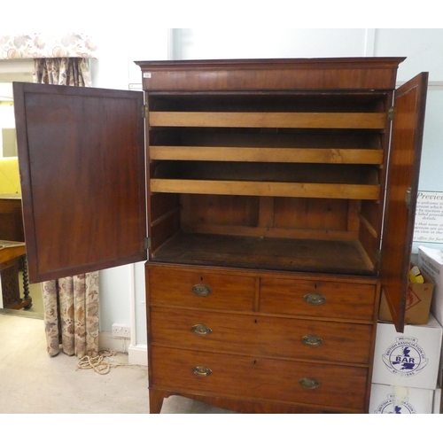 272 - An early Victorian mahogany linen press with a moulded cornice, over two panelled doors, enclosing t... 