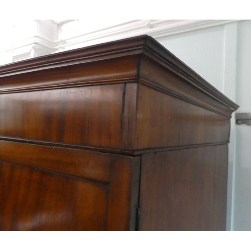 272 - An early Victorian mahogany linen press with a moulded cornice, over two panelled doors, enclosing t... 