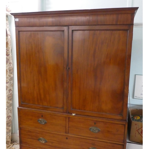 272 - An early Victorian mahogany linen press with a moulded cornice, over two panelled doors, enclosing t... 