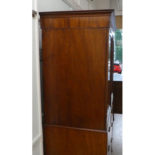 272 - An early Victorian mahogany linen press with a moulded cornice, over two panelled doors, enclosing t... 