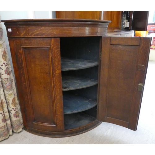 277 - A George III oak quadrant, twin panelled door, hanging corner cabinet, on a plinth  43