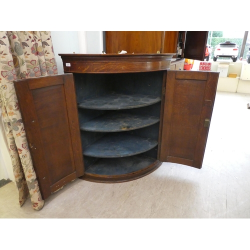 277 - A George III oak quadrant, twin panelled door, hanging corner cabinet, on a plinth  43