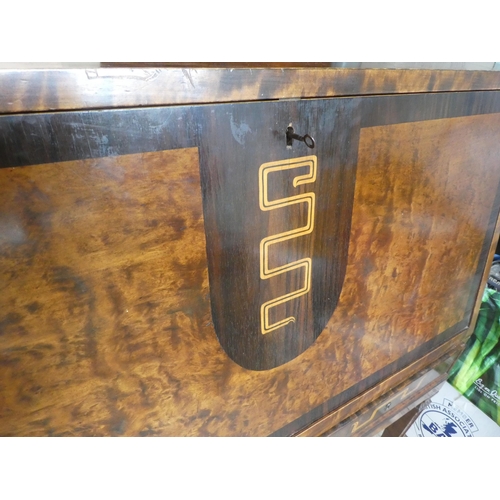 50 - An early 20thC walnut veneered bureau, the fall flap enclosing an arrangement of drawers and open sh... 