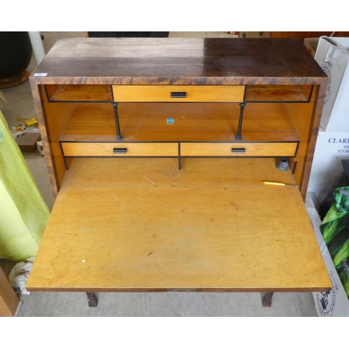 50 - An early 20thC walnut veneered bureau, the fall flap enclosing an arrangement of drawers and open sh... 