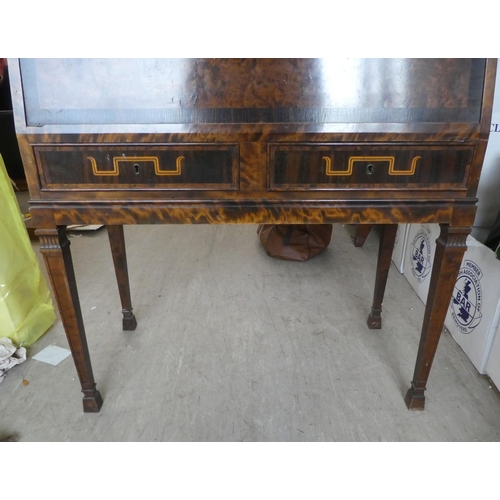 50 - An early 20thC walnut veneered bureau, the fall flap enclosing an arrangement of drawers and open sh... 