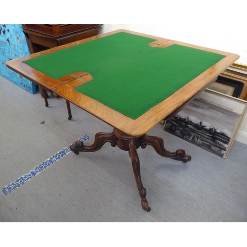 211 - A mid Victorian mahogany tea table, the rotating, foldover top over a bulbous column and carved quad... 