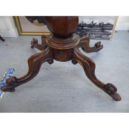 211 - A mid Victorian mahogany tea table, the rotating, foldover top over a bulbous column and carved quad... 