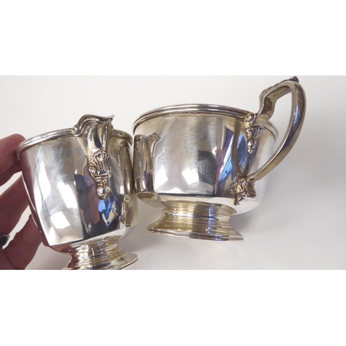 109 - A silver milk jug of panelled, octagonal form with a spout and handle, on a pedestal footrim; and a ... 