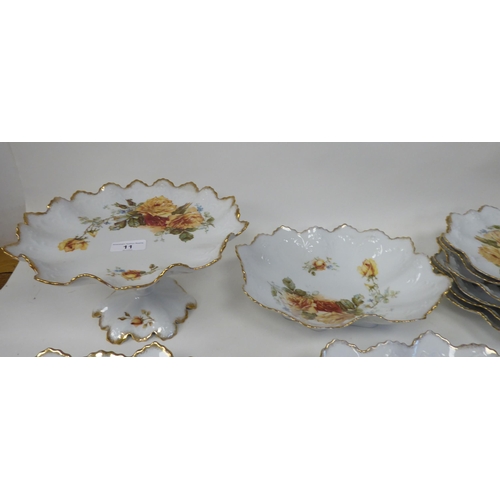 11 - An Austrian porcelain dessert service, decorated with trailing roses, comprising six frilled and gil... 