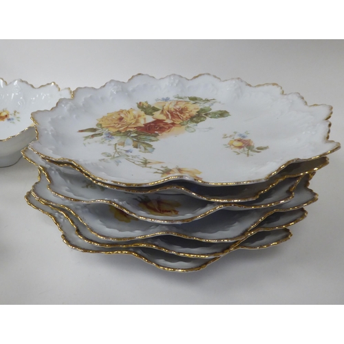 11 - An Austrian porcelain dessert service, decorated with trailing roses, comprising six frilled and gil... 