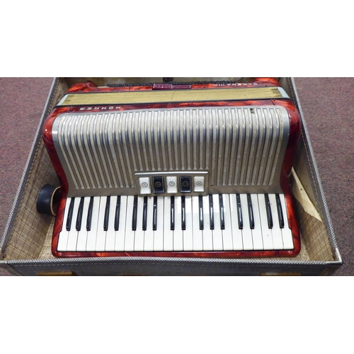 114 - A Hohner Carena IIIM, red marble effect cased piano accordion with a travel case