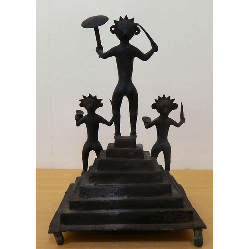 121 - A tribal blackened iron group, depicting three dancing figures, on a stepped base  13