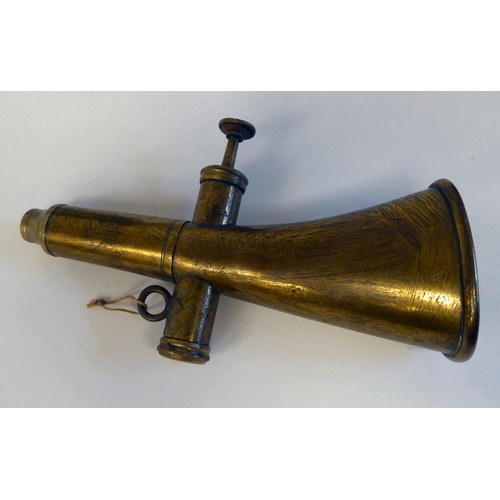 126 - A German Nazi era brass horn; a bronze cycling horn; and a spreadeagle and swastika iron vehicle emb... 