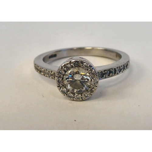 139 - A platinum engagement ring, set with a single brilliant cut central stone, surrounded by smaller on ... 