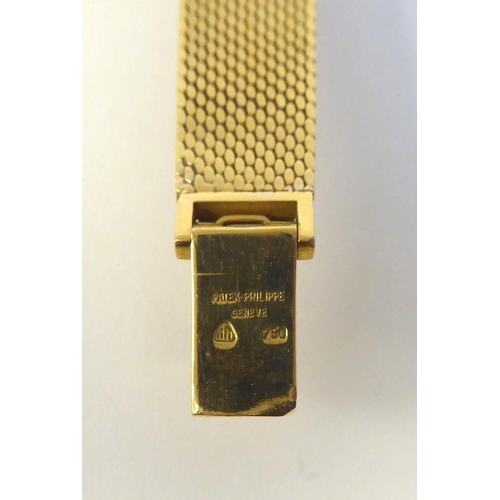 151 - A lady's Patek Phillipe 18ct gold cased bracelet wristwatch, faced by a silvered and gilded baton di... 