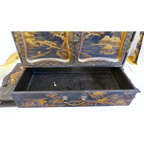 153 - An early 20thC Japanese black lacquered and gilded table cabinet, traditionally decorated in chinois... 