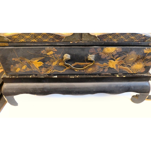 153 - An early 20thC Japanese black lacquered and gilded table cabinet, traditionally decorated in chinois... 