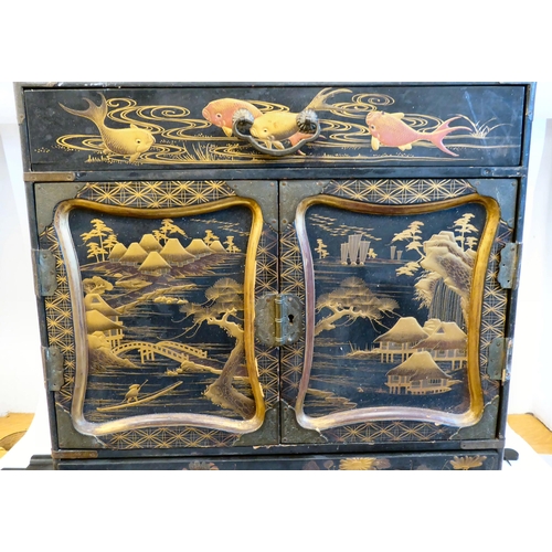 153 - An early 20thC Japanese black lacquered and gilded table cabinet, traditionally decorated in chinois... 