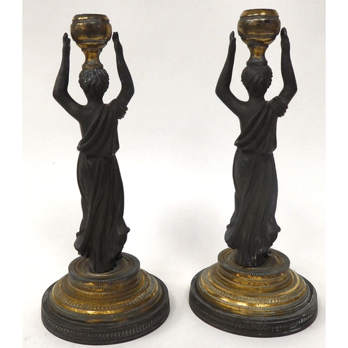 157 - A pair of mid Victorian taperstick holders, fashioned as cast and patinated female figures, each wea... 