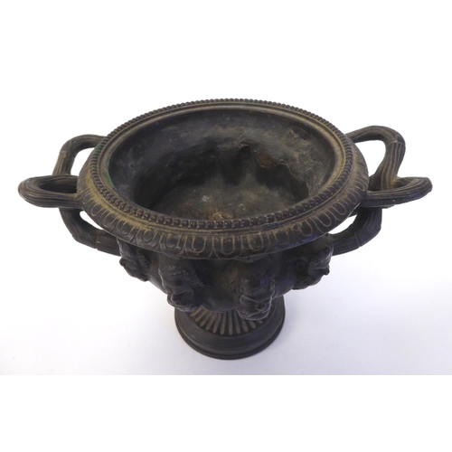 285 - A 19thC cast bronze, twin handled vase, depicting a frieze of eight male busts, on a pedestal base  ... 