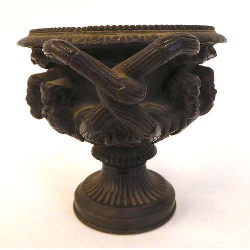 285 - A 19thC cast bronze, twin handled vase, depicting a frieze of eight male busts, on a pedestal base  ... 