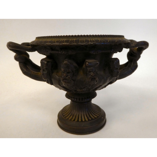 285 - A 19thC cast bronze, twin handled vase, depicting a frieze of eight male busts, on a pedestal base  ... 