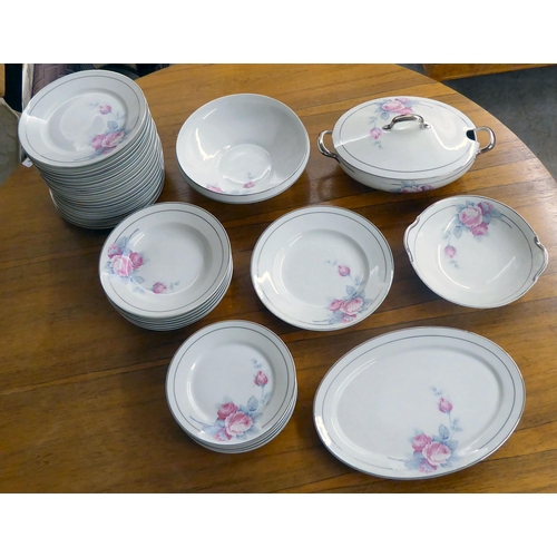 291 - A Limoges porcelain dinner service, decorated with pink roses and silver line trim