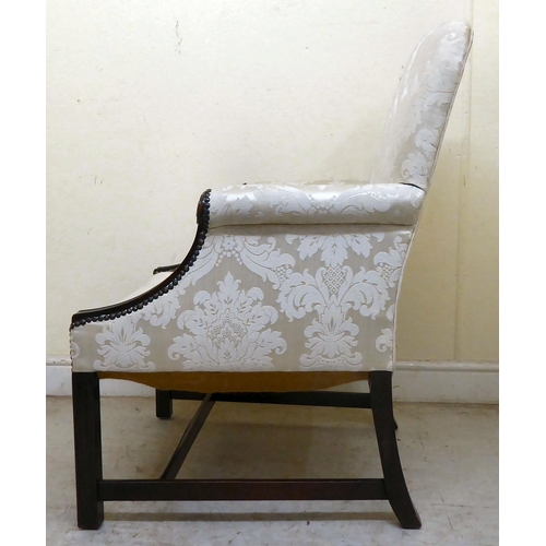 335 - A 20thC Gainsborough style mahogany showwood framed armchair, upholstered in cream coloured floral f... 