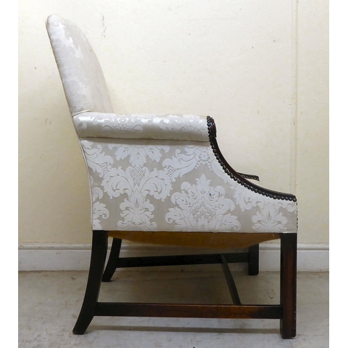 335 - A 20thC Gainsborough style mahogany showwood framed armchair, upholstered in cream coloured floral f... 