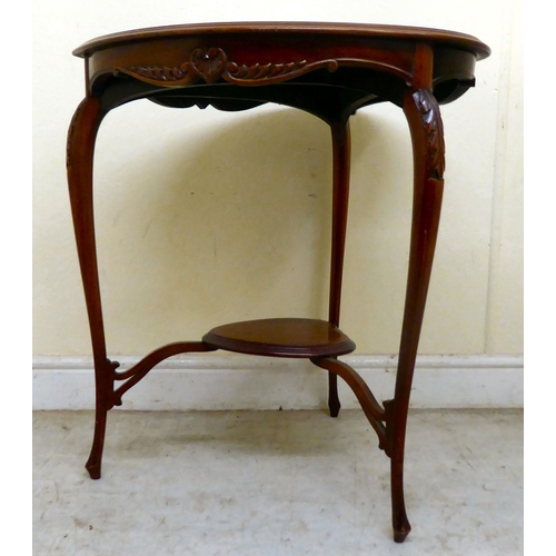 346 - An Edwardian mahogany heart shape occasional table, the top with a carved and shaped apron, raised o... 