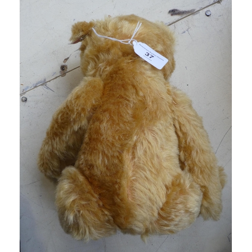 37 - A Steiff golden plush mohair covered Teddy bear with mobile limbs and a stitched nose  15