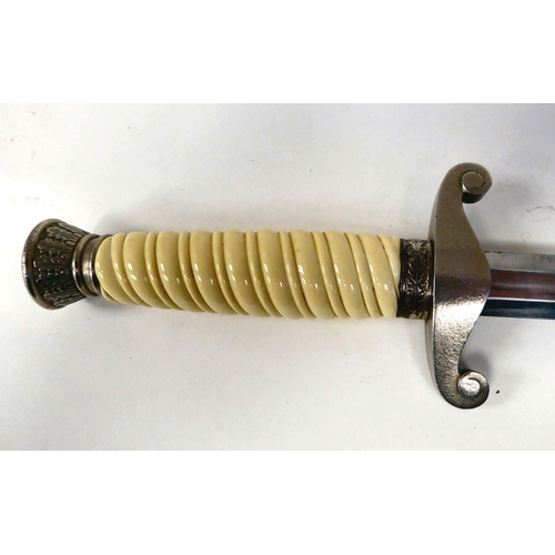 377 - A German Army officer's dagger with a cream coloured wrythen moulded grip and spreadeagle emblem on ... 