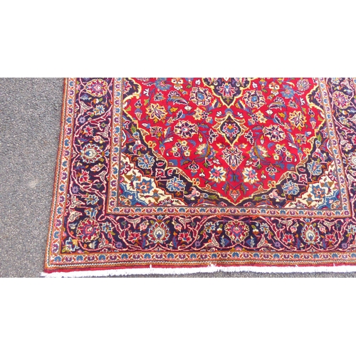 384 - A Kashan rug with floral motifs, on a red ground  83