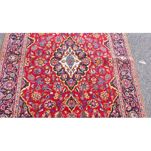 384 - A Kashan rug with floral motifs, on a red ground  83