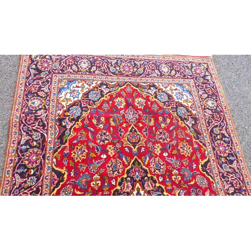 384 - A Kashan rug with floral motifs, on a red ground  83